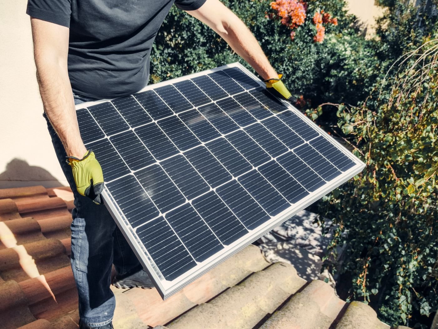 Close-up of solar modules clamped to rails on a tiled roof